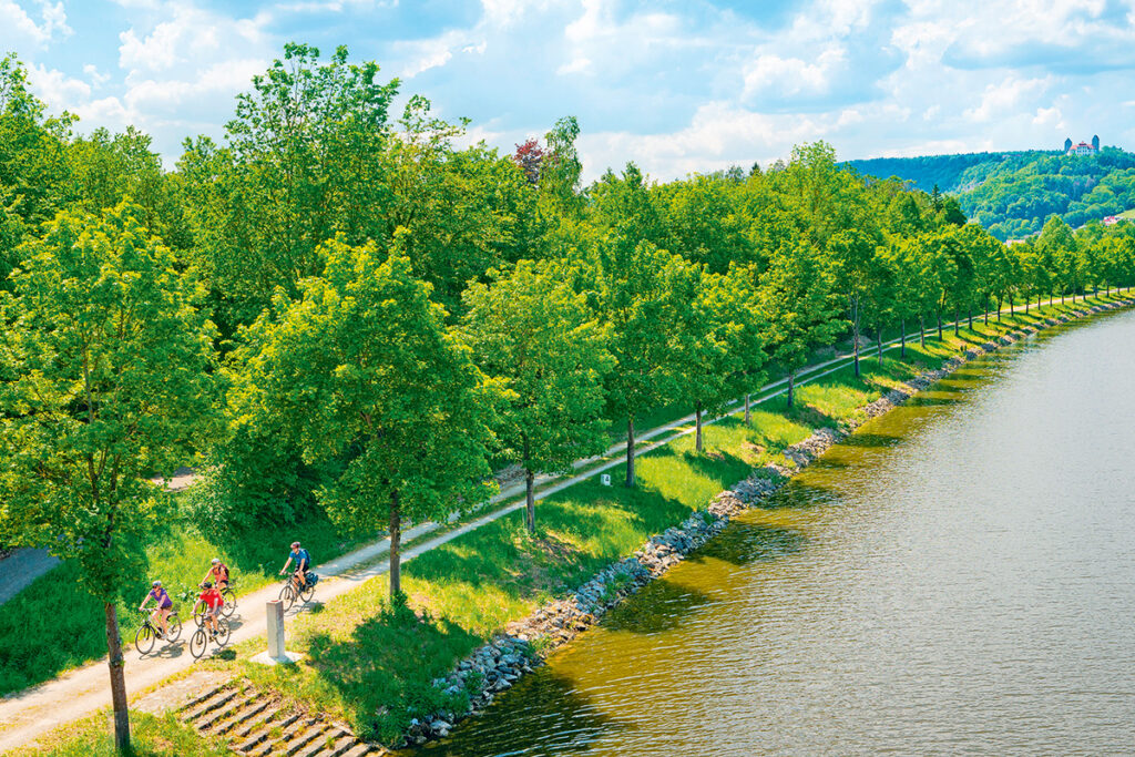 Radler am Kanal mit Schloss Hirschberg