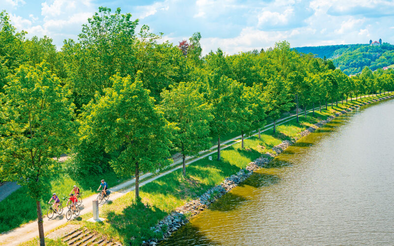 Radler am Kanal mit Schloss Hirschberg