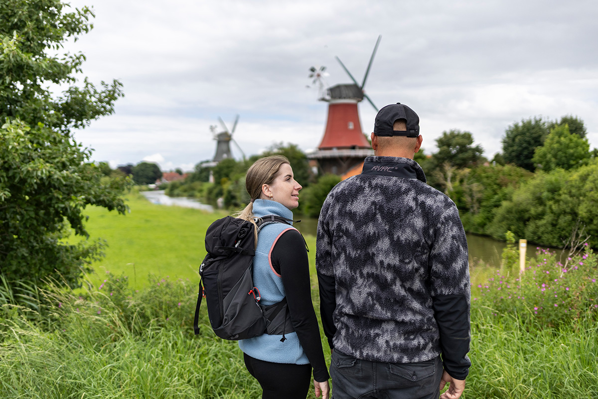 Wanderer an der Nordsee vor Windmühle